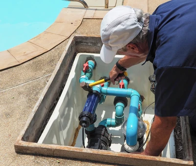 Couple se détendant dans une piscine intérieure, appuyés contre le rebord carrelé, ambiance spa et bien-être