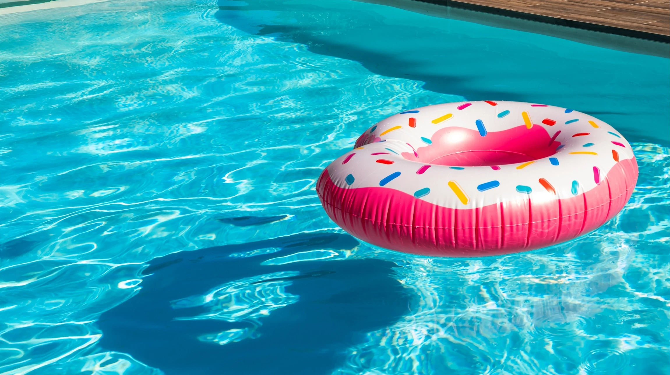 Piscine extérieure résidentielle avec bouée de sauvetage rouge et blanche accrochée à un poteau vert