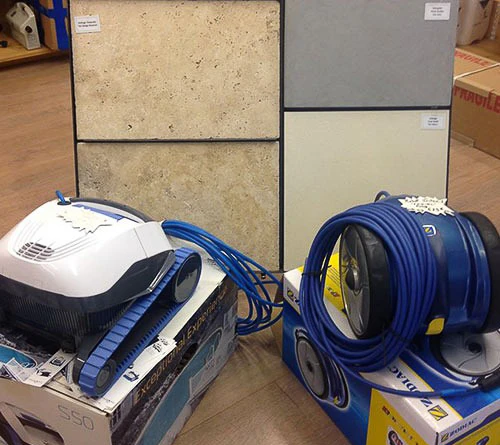 Piscine rectangulaire extérieure avec margelles en pierre claire, entourée de pelouse artificielle