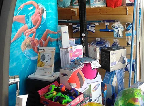 Piscine extérieure rectangulaire à angles arrondis installée dans jardin résidentiel avec terrasse en bois exotique