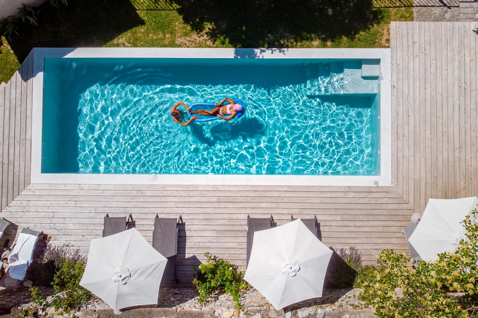 Piscine extérieure avec eau bleue cristalline et reflets lumineux ondulants à la surface